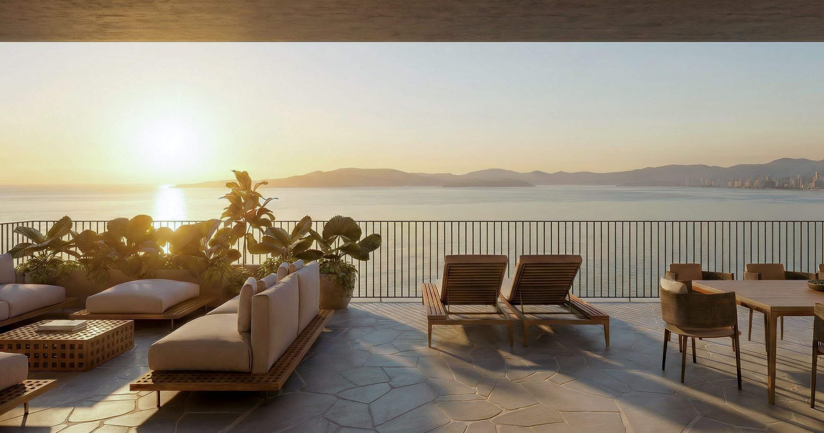 Living do duplex e penthouse do Vedá com terraço, espreguiçadeiras e vista do mar de Itapema ao pôr-do-sol